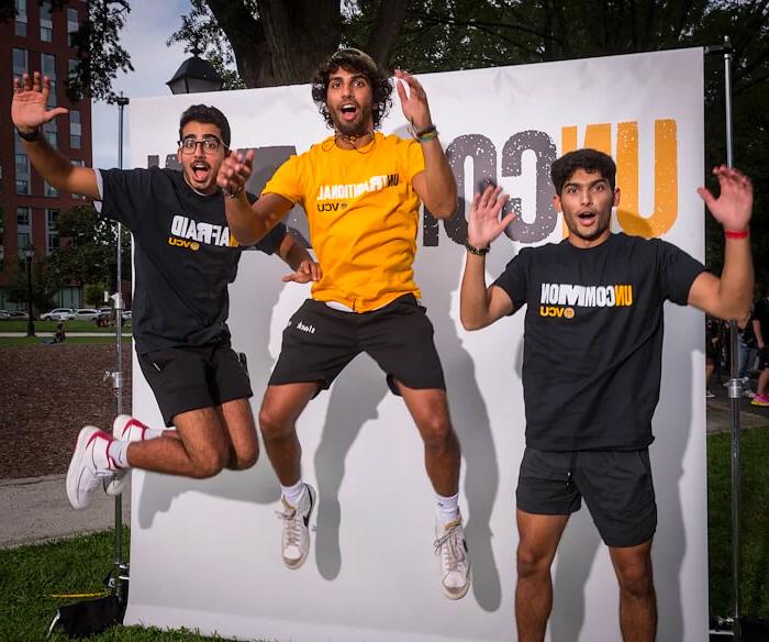 Three VCU students jumping in the air